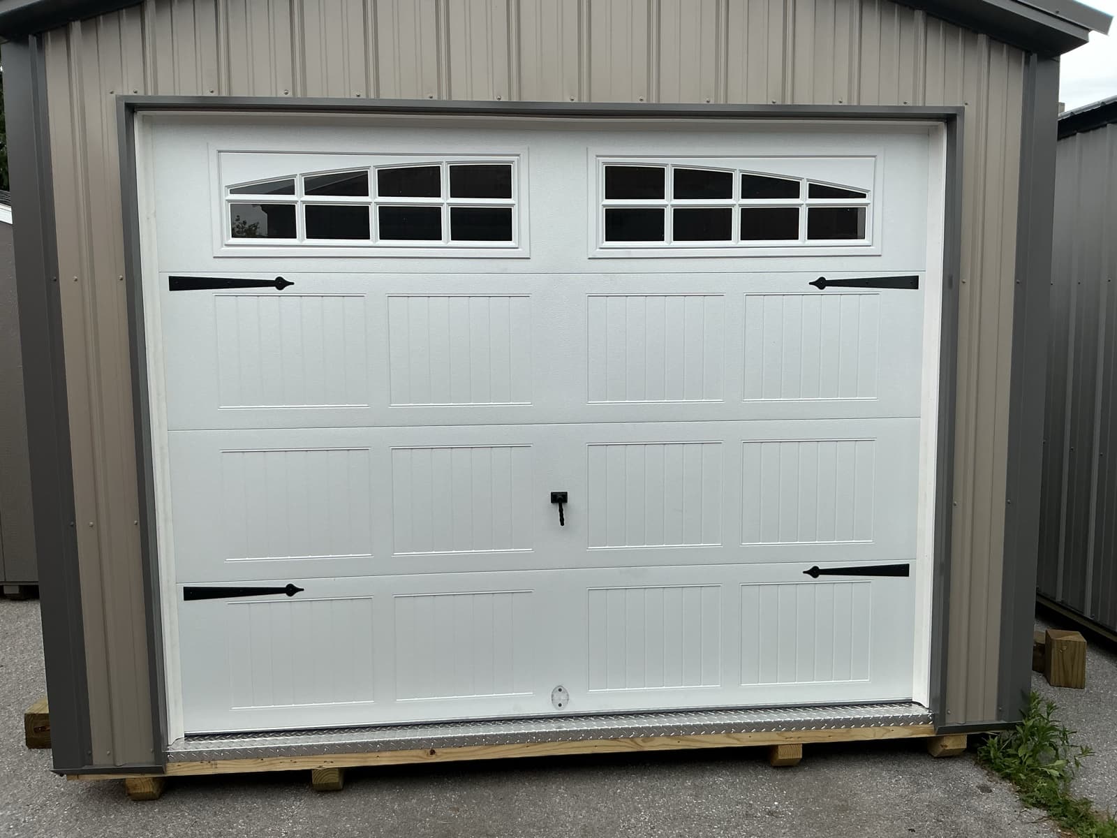 White carriage-house garage door with black decorative hardware